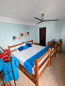 a bedroom with a bed with blue pillows and a ceiling at Casa Aguazul in Campeche