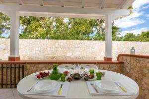 a white table with plates and vases on a porch at LaRosa Campomarino in Campomarino