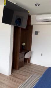 a room with a desk and a tv on a wall at KUKO SUITES in Chilpancingo de los Bravos