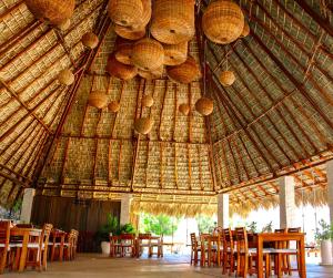 um grande pavilhão de palha com mesas e cadeiras em Hotel Marina Resort & Beach Club em Santa Cruz Huatulco