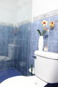 łazienka z toaletą i wazą z kwiatami w obiekcie Hotel WC w mieście Bogota