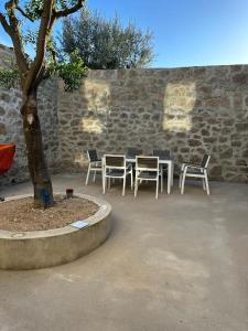 a group of chairs and a table and a tree at 3 Marias São Sebastião in Lousa