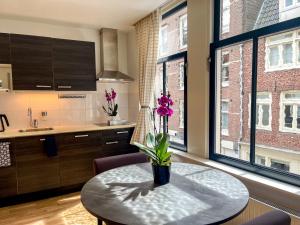 a kitchen with a table with flowers on it at Artist House Amsterdam in Amsterdam
