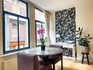 a dining room with a table and two windows at Artist House Amsterdam in Amsterdam +29 photos