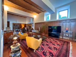 a large living room with yellow chairs and a rug at Tenuta Massabò in San Casciano in Val di Pesa