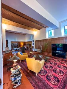 a living room with yellow chairs and a large rug at Tenuta Massabò in San Casciano in Val di Pesa