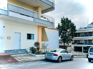 een witte auto geparkeerd voor een gebouw bij Ithaca: Διαμέρισμα με αυτόνομη είσοδο. in Thessaloniki