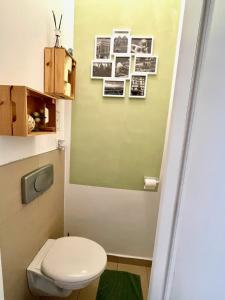 a bathroom with a toilet and pictures on the wall at Centra and simple to reach in Vienna