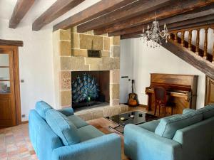 a living room with two blue couches and a fireplace at Le Clos Papillon in Corcelles-les-Monts