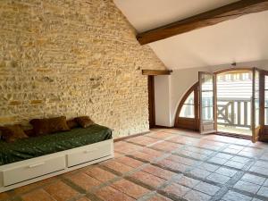 una camera con divano contro un muro di mattoni di Le Clos Papillon a Corcelles-les-Monts