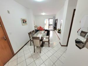 a dining room and living room with a table and chairs at Apartamento 200 metros da praia 03 quartos com ar condicionado - Meia Praia - Itapema in Itapema