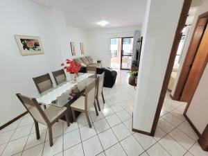 - une salle à manger et un salon avec une table et des chaises dans l'établissement Apartamento 200 metros da praia 03 quartos com ar condicionado - Meia Praia - Itapema, à Itapema