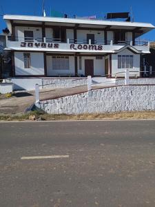 a white building with a fence in front of it at Joyous Rooms in Cherrapunji