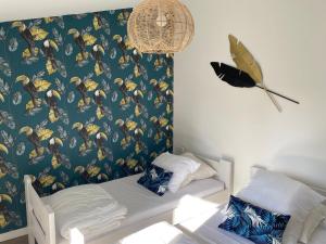ein Schlafzimmer mit einem Bett und einer Wand mit einer Schmetterlingstapete in der Unterkunft Cosy T3 dans corps de ferme l écureuil 