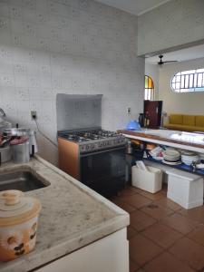 a kitchen with a stove and a counter top at Casa com piscina em Bertioga in Bertioga