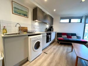 a kitchen with a washing machine and a sink at Albert Road, Bournemouth Town in Bournemouth