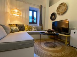 sala de estar con sofá, TV y mesa en Maria’s Cottage House, en Kalymnos