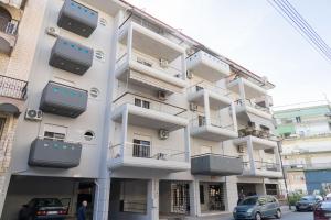 a tall white building with balconies on it at THE WHOLE PACKET Β3 center with parking in Larisa