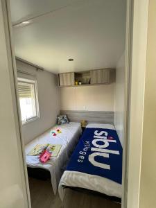 a small room with two beds in it at Mobil Home 2CH Bien Equipé Valras-Plage in Sérignan