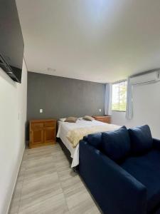 1 dormitorio con 1 cama y 1 sofá azul en Hotel Backdoor, en Imbituba