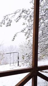 una ventana con vistas a un árbol cubierto de nieve en Racha Nanida en Agara