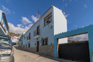 un edificio azul y blanco al lado de una calle en la casa del bosque, en Júzcar