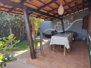 een patio met een tafel en stoelen onder een pergola bij Little Kamala in Pipa