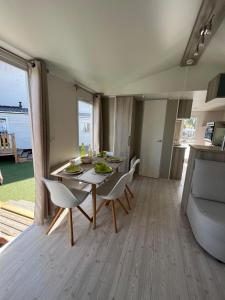 a dining room with a table and chairs and a couch at Mobil Home 2CH Bien Equipé Valras-Plage in Sérignan