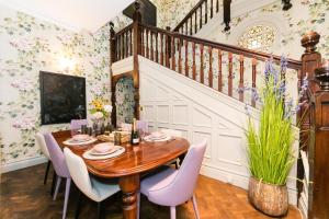 uma sala de jantar com uma mesa de madeira e cadeiras roxas em Hillthorpe Manor by Maison Parfaite - Large Country House with Hot Tub em Pontefract