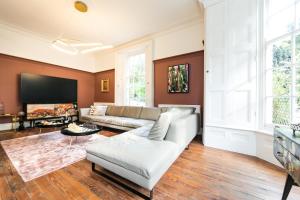 uma sala de estar com um sofá e uma televisão em Hillthorpe Manor by Maison Parfaite - Large Country House with Hot Tub em Pontefract