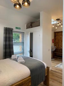 a bedroom with a bed with two towels on it at Butterfly Cottage in Grantown on Spey