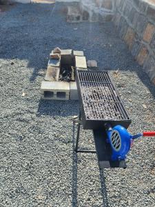 a grill sitting on top of a pile of gravel at Sunset view hill jabal shams in Misfāh