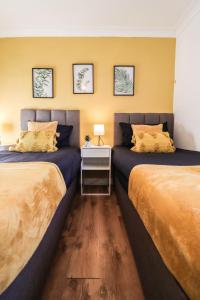 duas camas sentadas uma ao lado da outra num quarto em FREE Parking, 1 bedroom apartment close to HEATHROW em Stanwell