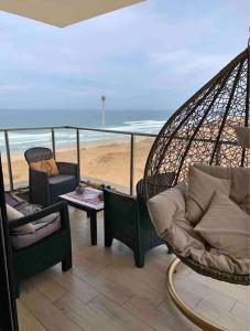 una veranda con amaca, sedie e spiaggia di Stylish apartment with sea view a Salé
