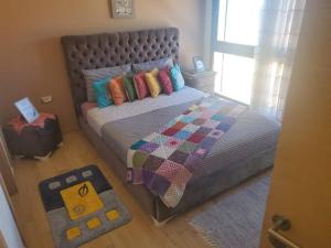 una camera con un letto con una trapunta e un tappeto di Stylish apartment with sea view a Salé