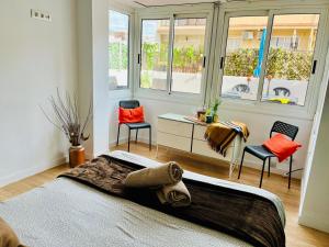 een slaapkamer met een bed, een bureau en 2 stoelen bij Calm Terrace Barcelona in Barcelona