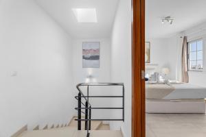 a white bedroom with a bed and a glass table at Villa Atlántica - Heated pool in Playa Blanca in Playa Blanca