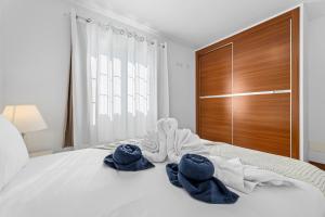 a bedroom with towels on a bed with a wooden door at Villa Atlántica - Heated pool in Playa Blanca in Playa Blanca