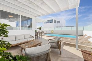 a living room with a couch and a pool at Villa Atlántica - Heated pool in Playa Blanca in Playa Blanca