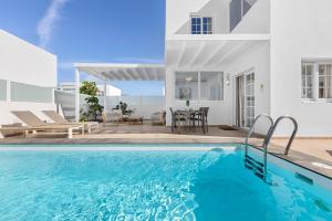 a villa with a swimming pool and a patio at Villa Atlántica - Heated pool in Playa Blanca in Playa Blanca