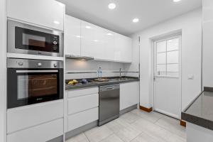 a kitchen with stainless steel appliances and white cabinets at Villa Atlántica - Heated pool in Playa Blanca in Playa Blanca