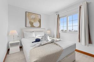 a white bedroom with a bed and a window at Villa Atlántica - Heated pool in Playa Blanca in Playa Blanca
