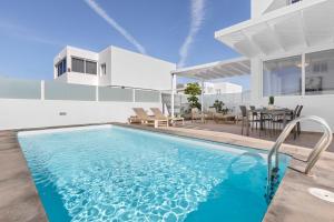 a villa with a swimming pool and a house at Villa Atlántica - Heated pool in Playa Blanca in Playa Blanca