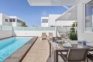 a patio with a table and a swimming pool at Villa Atlántica - Heated pool in Playa Blanca in Playa Blanca
