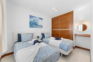 a bedroom with two beds and a wall with a wave at Villa Atlántica - Heated pool in Playa Blanca in Playa Blanca
