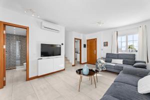 a living room with a couch and a tv at Villa Atlántica - Heated pool in Playa Blanca in Playa Blanca