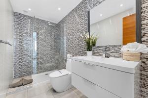 a white bathroom with a toilet and a sink at Villa Atlántica - Heated pool in Playa Blanca in Playa Blanca