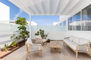 an outdoor patio with a couch and chairs at Villa Atlántica - Heated pool in Playa Blanca in Playa Blanca