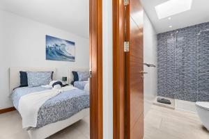 a bedroom with a bed and a bathroom with a shower at Villa Atlántica - Heated pool in Playa Blanca in Playa Blanca