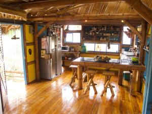 a kitchen with a wooden table and a refrigerator at Simply Paradise in Mompiche